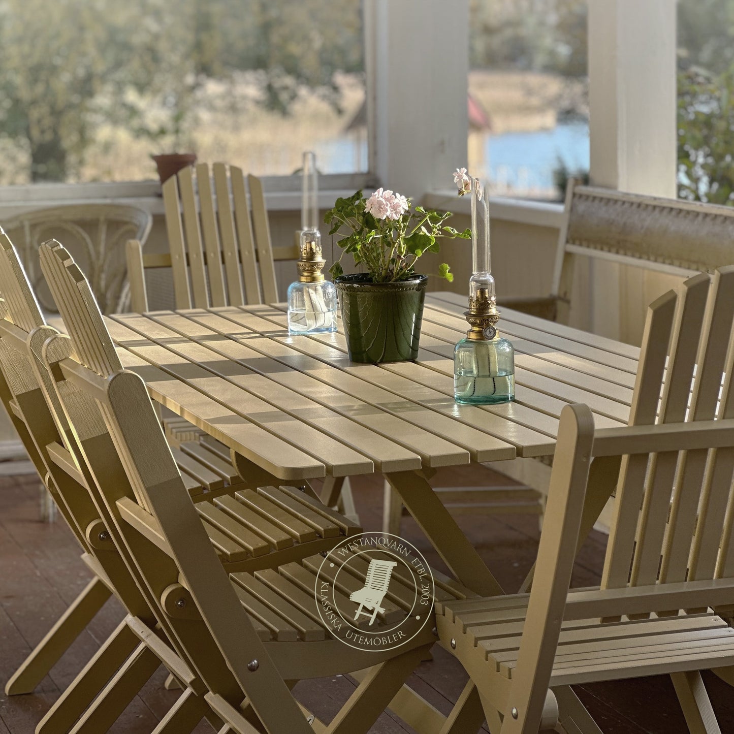 Wooden outdoor dining table with chairs on a deck with a scenic view.